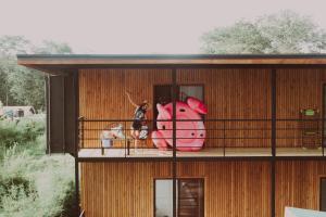 a house with a pink pig on a balcony at Kanoa Lodge - Adults and 18 plus only in Pavones