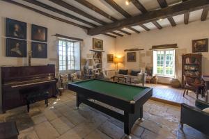 - un salon avec un billard et un piano dans l'établissement Le prieuré Saint Barthélémy, à Azay-le-Brûlé