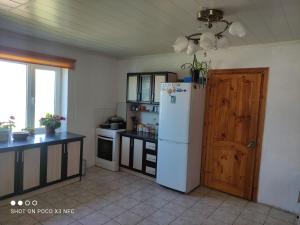 a kitchen with a white refrigerator and a stove at Guest House Doktor Eismann in Chychkan