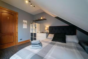a bedroom with a large bed with a black headboard at Stunning Central Villa by Golf Course & Beach in Leven