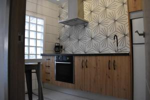 a kitchen with wooden cabinets and a black stove top oven at Rua 82 Apartamentos in Ibdes