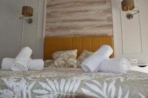 una cama con almohadas blancas encima en Rua 82 Apartamentos, en Ibdes