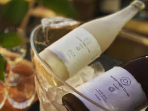 Una botella de vino está sentada en una copa en Nordisk Hygge Circles Ugakei - Vacation STAY 75319v en Komono