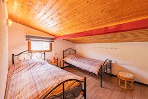2 łóżka w pokoju z drewnianym sufitem w obiekcie Gite Haven w mieście Maissin