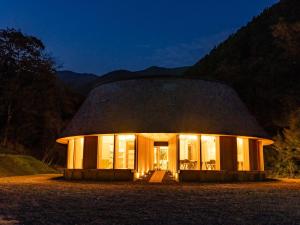 una casa redonda con techo de paja por la noche en Nordisk Hygge Circles Ugakei - Vacation STAY 75319v en Komono