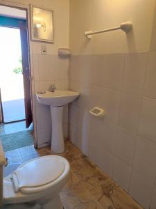 a bathroom with a toilet and a sink at Hosteria LAS ISLAS in Comunidad Yumani