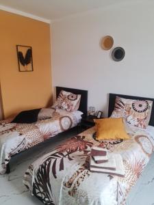 a bedroom with two beds with colorful pillows at Deluxe B&B "Casa Alegria", Tarrafal in Tarrafal