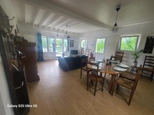 ein Esszimmer und ein Wohnzimmer mit einem Tisch und Stühlen in der Unterkunft Les chambrées du bac in Charly-sur-Marne