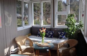 a porch with a table and chairs and windows at Horská Chata Gírová in Bukovec