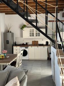 a kitchen with white cabinets and a table in a room at Petrospito by the sea! in Neos Marmaras