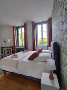Châtelraould-Saint-LouventにあるDomaine de Beaucampの大きなベッドと2つの窓がある寝室