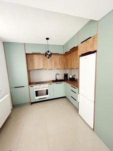 an empty kitchen with white cabinets and a refrigerator at NS apartment 2 in Cluj-Napoca