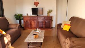 uma sala de estar com dois sofás e uma televisão em Casa de Temporada - Solar Guest House em Saquarema
