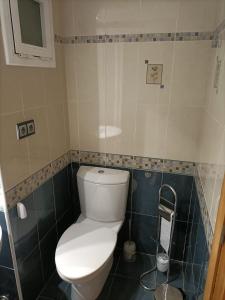 La salle de bains est pourvue de toilettes blanches et de carrelage bleu. dans l'établissement 231Rooms&More, à Reus