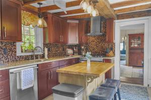 cocina con armarios de madera y encimera de madera en Last House on the River, en Stonington