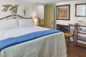a bedroom with a bed with a blue and white blanket at Last House on the River in Stonington +42 photos