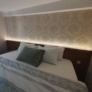1 dormitorio con 1 cama con cabecera y almohadas en Denis suit apart en Estambul