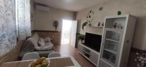 sala de estar con sofá y TV en Apartamento Fez playa de la barrosa, en Chiclana de la Frontera