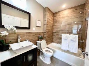 a bathroom with a toilet and a tub and a sink at 402 Stylish luxe Apt at center city self check-in in Philadelphia +42 photos