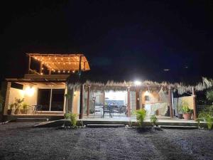 une maison avec une terrasse éclairée la nuit dans l'établissement Casa De Descanso KAYKA, à La Ventana