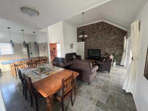 Una sala de estar con una mesa y sillas de madera. en Stay@51 Botha, en Oudtshoorn