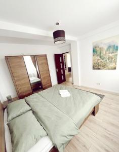 a bedroom with a bed with a green blanket at NS apartment 2 in Cluj-Napoca