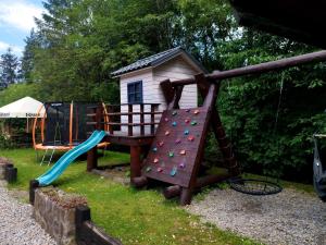 un parque infantil con tobogán y una casa de juegos en Karczma Karnasów, en Cisna