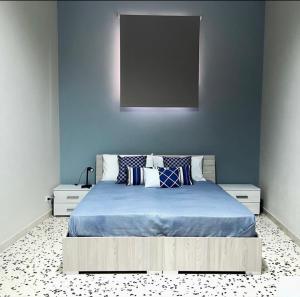 una camera blu con letto con lenzuola e cuscini blu di Sisters appartamenti a Castelvetrano Selinunte