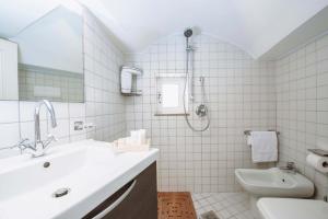 a white bathroom with a sink and a shower at Casa Vacanze Cisternino alcova nel centro storico in Cisternino +11 photos