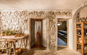 a room with a stone wall with a table and a doorway at Agriturismo Borgo Titol in Tramonti di Sopra