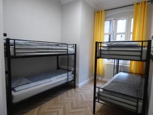 two bunk beds in a room with a window at Gingerbread Hostel in Toruń