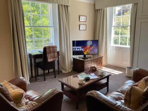 a living room with a couch and a coffee table at Chatton Park House Adult Only in Chatton