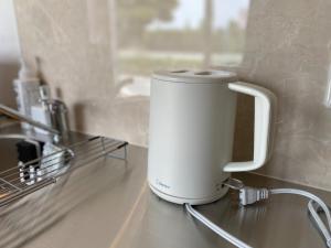 a whiteffeepot sitting on a kitchen counter at THE LAND HOTEL - Vacation STAY 89165v in Arao
