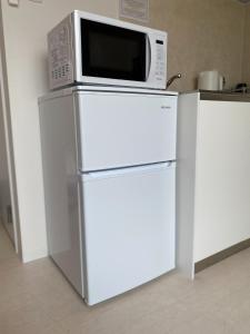 a microwave sitting on top of a refrigerator at THE LAND HOTEL - Vacation STAY 89165v in Arao