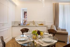 a dining room with a glass table and chairs at Île Déluxe Apartment in Sorrento