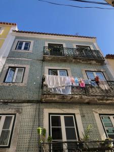 リスボンにあるLisbon Inn Bica Suitesのバルコニーに掛けられた洗濯物のある建物