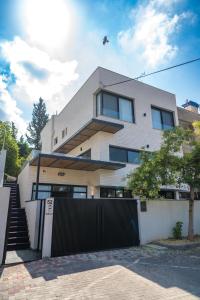 uma casa branca com uma cerca à frente. em Rokah Luxury Villa at Ramat HaHayal em Tel Aviv