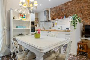 a kitchen with a white table with a vase on it at Hauzify I Casa d'Anselm Clavé in Calella