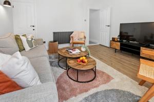 ein Wohnzimmer mit einem Sofa und einem Tisch mit Obst darauf in der Unterkunft Cosy & Bright Home with Backyard in Southsea Portsmouth in Portsmouth