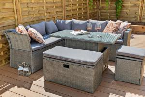 a patio with a couch and a table and chairs at Cosy & Bright Home with Backyard in Southsea Portsmouth in Portsmouth