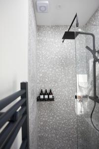 a bathroom with a shower with three bottles on a shelf at Cosy & Bright Home with Backyard in Southsea Portsmouth in Portsmouth