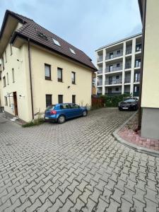a blue car parked in a parking lot next to a building at NS apartment 2 in Cluj-Napoca
