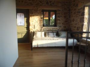 um quarto com uma cama numa parede de pedra em Villa ALONIA em Kalamata