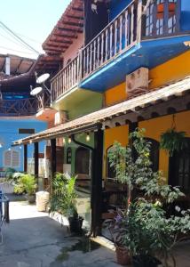 ein farbenfrohes Gebäude mit Pflanzen davor in der Unterkunft Angel Ilha Flats e Varanda da Praia in Abraão