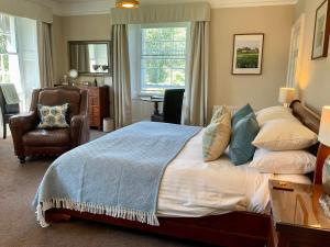 - une chambre avec un grand lit et une chaise dans l'établissement Chatton Park House Adult Only, à Chatton