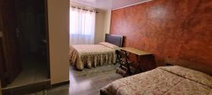 a hotel room with three beds and a window at Torotoro Hostal El Olvido in Torotoro