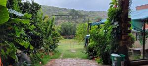 einen Garten mit einem steinernen Gehweg zwischen zwei Gebäuden in der Unterkunft Torotoro Hostal El Olvido in Torotoro