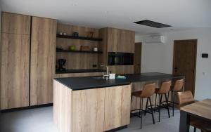 una cucina con armadi in legno e piano di lavoro nero di Vakantiewoning Den Appel a Dendermonde