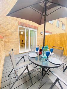 een tafel en stoelen met een parasol op een patio bij Vileto apartment in central Bournemouth in Bournemouth