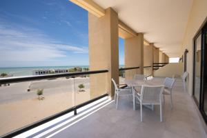 a balcony with a table and chairs and the beach at Laguna Shores Resort in Puerto Peñasco